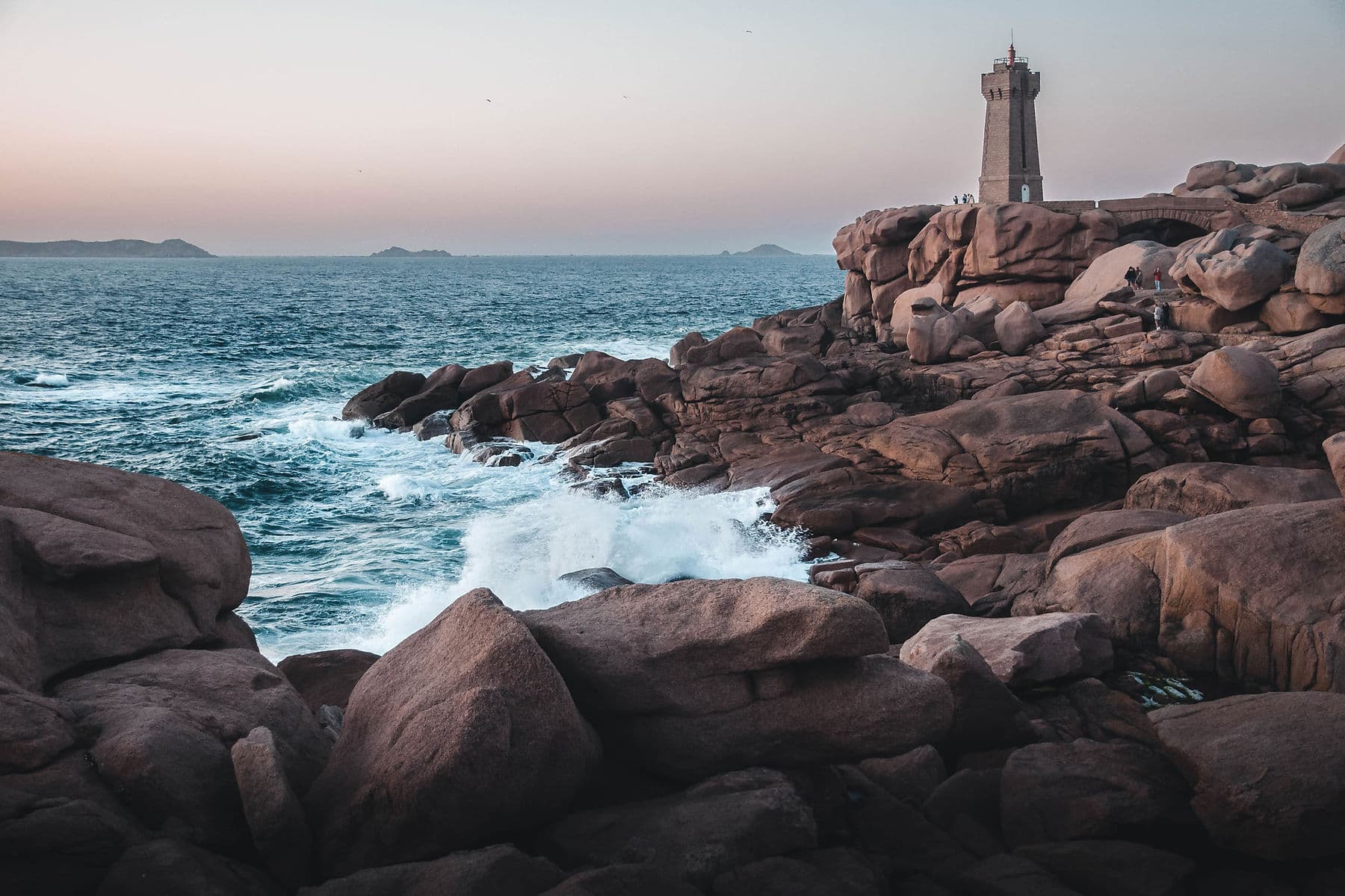 Lighthouse standing above rocks and water